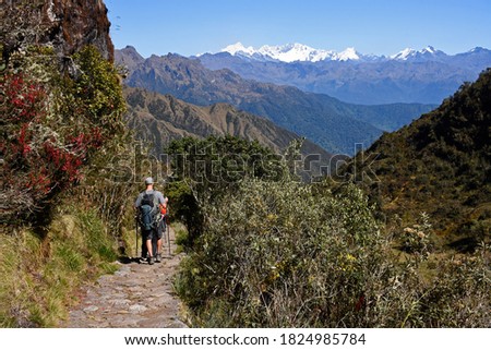 People hiking in the Andes in Inka Trail enroute to Macchu Picchu passing through some of the ruins.