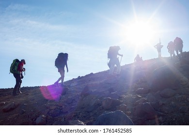 People hiking up the Red Crater with the sunrays shining on the Tongariro Alpine Crossing in New Zealand.