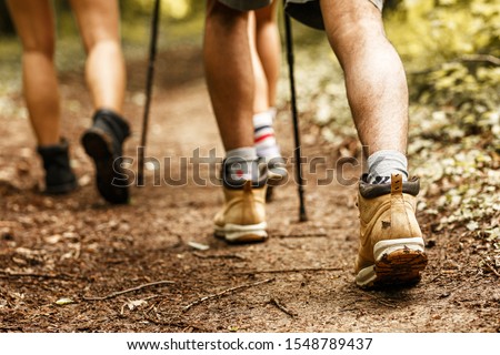 People hiking.Only legs and tracking boots are visible.
