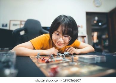 People Hobbies Lifestyle Stay At Home Concept. Young Adult Asian Woman Playing Board Game On Top Table. 