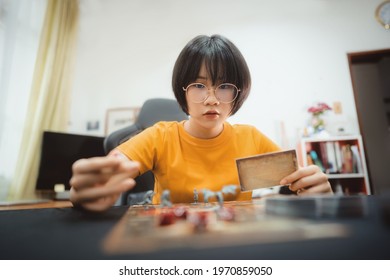 People Hobbies Lifestyle Stay At Home Concept. Young Adult Asian Woman Playing Board Game On Top Table. 