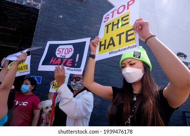 People hold signs to protest hate crimes committed against Asian-American and Pacific Islander communities ahead of a car caravan in Koreatown on March 19, 2021 in Los Angeles. 