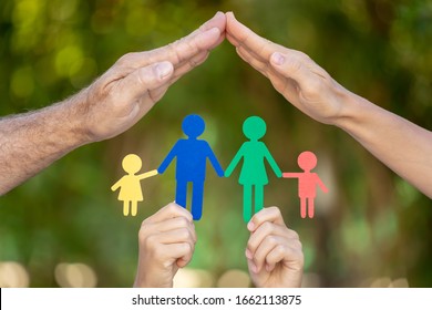 People Holding Paper Family In Hands Against Spring Green Background. Healthy Lifestyle Concept