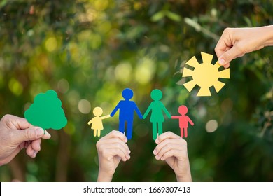 People Holding Paper Family In Hands Against Spring Green Background. Healthy Lifestyle Concept