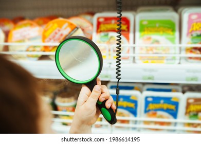 people holds magnifying glass in hand in store and looks at price of product through it. adaptation of stores for people with disabilities. comfortable life with poor eyesight. selective focus - Powered by Shutterstock