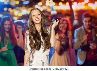 People, Holidays, Celebration And Glamour Concept - Happy Young Woman Or Teen Girl In Fancy Dress With Sequins At Night Club Party Over Crowd And Lights Background