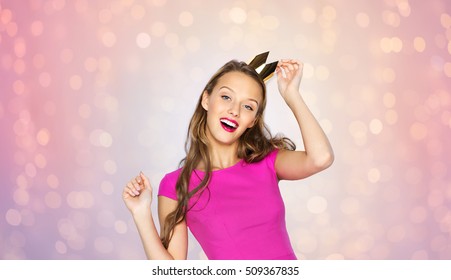 people  holidays   fashion concept    happy young woman teen girl in pink dress   princess crown over rose quartz   serenity lights background