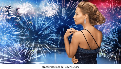 People, Holidays, Party, Jewelry And Glamour Concept - Beautiful Woman With Diamond Earring Over Firework Lights In City Background