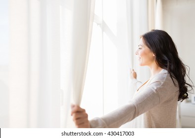 people and hope concept - close up of happy woman opening window curtains