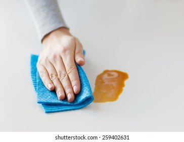 People, Housework And Housekeeping Concept - Close Up Of Woman Hand Cleaning Dirty Table Surface With Cloth At Home