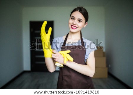 People, housework, safety and housekeeping concept. Young woman hands wearing protective rubber gloves