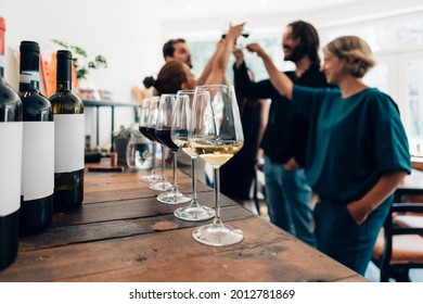 people inside a bar chilling out with a drink - friends talking and drinking in a winery - Millennials toasting at a wine tasting - Shutterstock ID 2012781869