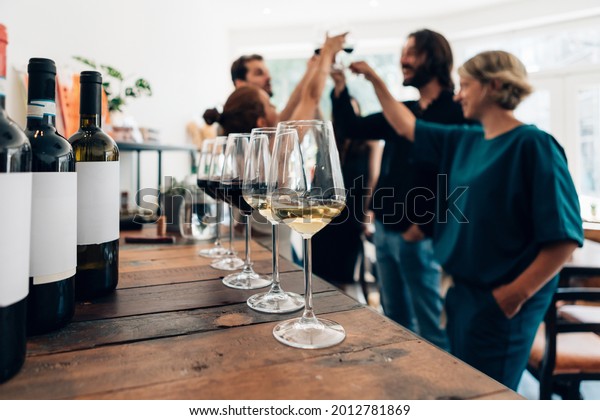 people inside a bar chilling out with a drink -\
friends talking and drinking in a winery - Millennials toasting at\
a wine tasting