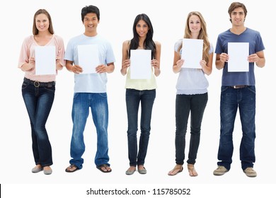 People in jeans holding five signs against white background