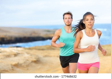 People Jogging For Fitness Running In Beautiful Landscape Nature Outdoors. Woman And Man Sports Athletes Training Cross-country Trail Running. Couple Together, Asian Woman, Caucasian Man,