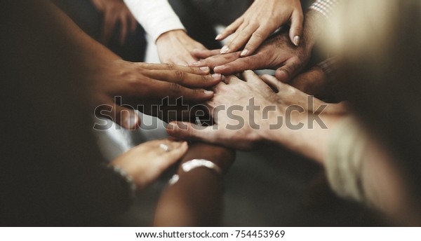 People with joined hands as a
team