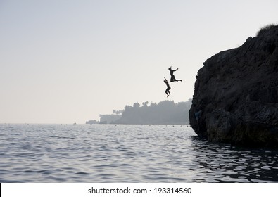 People jumping into the water from cliff