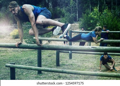 People jumping over the hurdles during obstacle course in boot camp