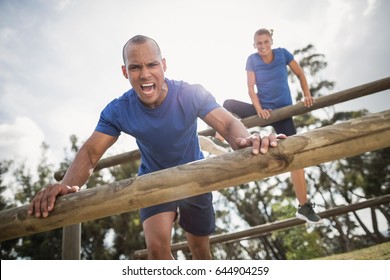 People jumping over the hurdles during obstacle course in boot camp - Powered by Shutterstock