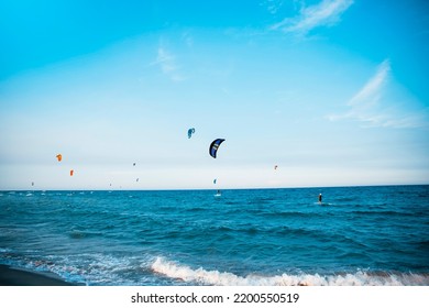 People Kitesurfing On A Blue Sea. Extreme Kite Surf Water Sports Background.