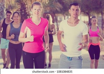 People leading healthy lifestyle, jogging during outdoor workout on city seafront - Shutterstock ID 1081084835