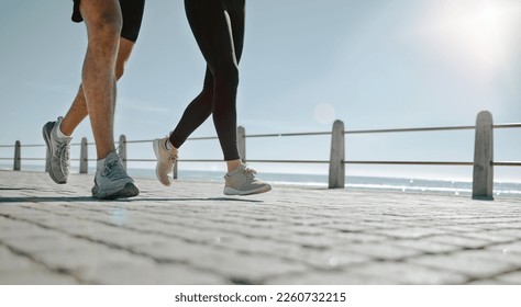 People, legs and running at the beach for exercise, cardio workout or training together outdoors. Leg of friends taking run, walk or jog on warm sunny day by the ocean coast for healthy wellness - Powered by Shutterstock