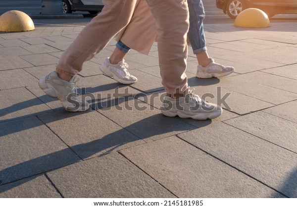 People\
legs walking on busy street on sunny\
afternoon.