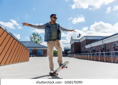 people and leisure concept - smiling indian man doing trick on skateboard on roof top - Powered by Shutterstock