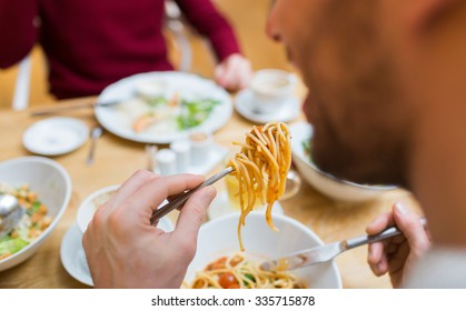 People, Leisure And Food Concept - Close Up Man Eating Pasta For Dinner At Restaurant Or Home