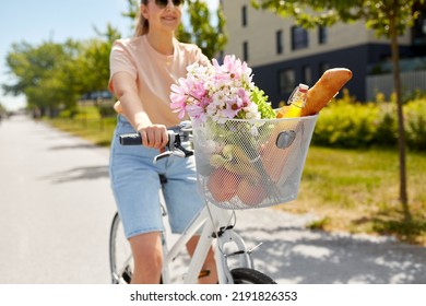 People, Leisure And Lifestyle - Close Up Of Happy Woman With Food And Flowers In Basket Of Bicycle On City Street