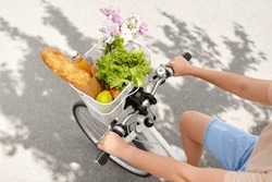 People, Leisure And Lifestyle - Close Up Of Woman With Food And Flowers In Basket Of Bicycle On City Street