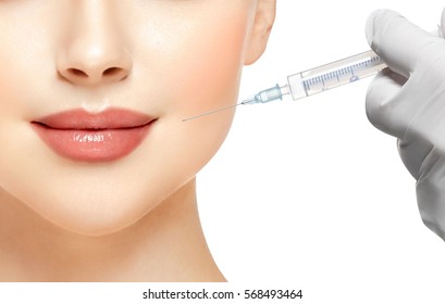People, Lips, cosmetology, plastic surgery and beauty concept - beautiful young woman face and hand in glove with syringe making injection