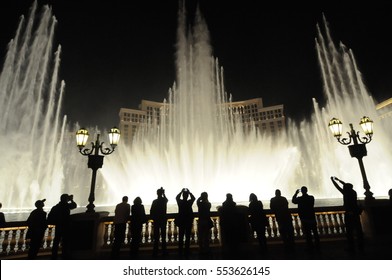 People look at night view of the fountain of Bellagio, Las Vegas, Nevada, USA
