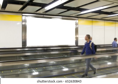 People Looking Blank Billboard In The City Building, Shot In Subway Station. Useful For Your Advertising.Selective Focus.