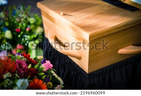 People loss and mourning concept, Closeup beautiful flower with wooden coffin  before funeral or burial at cemetery, a funeral service. 