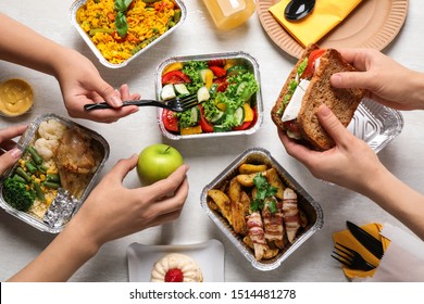 People with lunchboxes at white wooden table, top view. Healthy food delivery - Shutterstock ID 1514481278