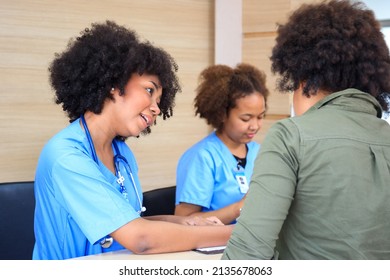 People Making An Appointment With Medical Staffs At Reception Desk In Hospital. Medical Staff And Nurse - Receptionist Talking To Patient In Front Of The Reception Counter In Hospital.