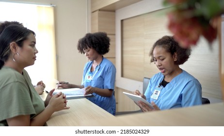 People making an appointment with medical staffs at reception desk in hospital. Medical staff and nurse - receptionist talking to patient in front of the reception counter in hospital. - Shutterstock ID 2185024329