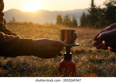 People Making Hot Drink With Portable Gas Burner In Mountain Camping, Closeup