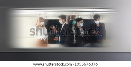 People with masks inside train , People on the train wear anti-virus masks and travel during rush hours. passengers inside the Sky Train , business people standing in metro mass transit subway.