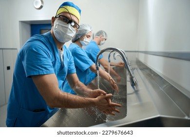 People in medical gowns wash their hands before the operation - Powered by Shutterstock