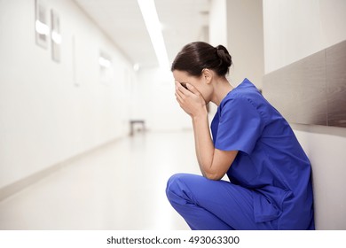 People, Medicine, Healthcare And Sorrow Concept - Sad Or Crying Female Nurse At Hospital Corridor