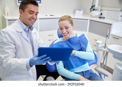 People, Medicine, Stomatology And Health Care Concept - Happy Male Dentist Showing Tablet Pc Computer To Woman Patient At Dental Clinic Office