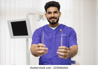 People, medicine, stomatology and healthcare concept. Confident young male bearded dentist with tools standing in light modern medical office background. - Powered by Shutterstock