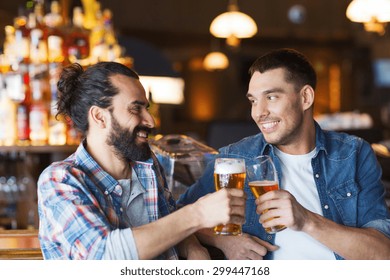 People, Men, Leisure, Friendship And Celebration Concept - Happy Male Friends Drinking Beer And Clinking Glasses At Bar Or Pub