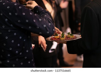 People mingle with canapes