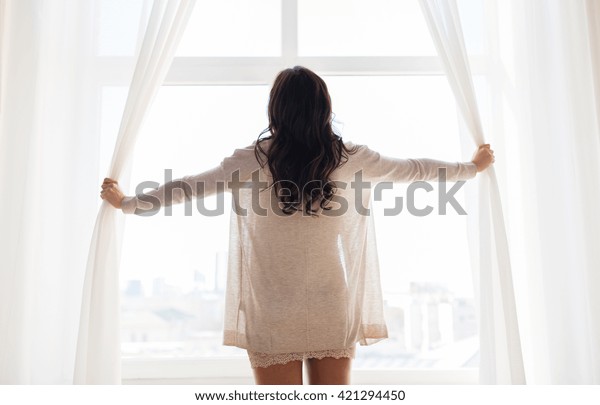 人と朝のコンセプト 家で窓のカーテンを開ける幸せな女性の接写 の写真素材 今すぐ編集
