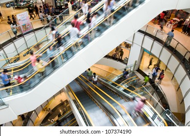 People In Motion In Escalators At The Modern Shopping Mall.