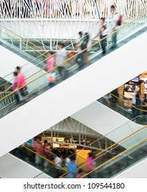 People In Motion In Escalators At The Modern Shopping Mall.