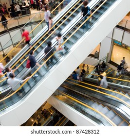 People In Motion In Escalators At The Modern Shopping Mall.